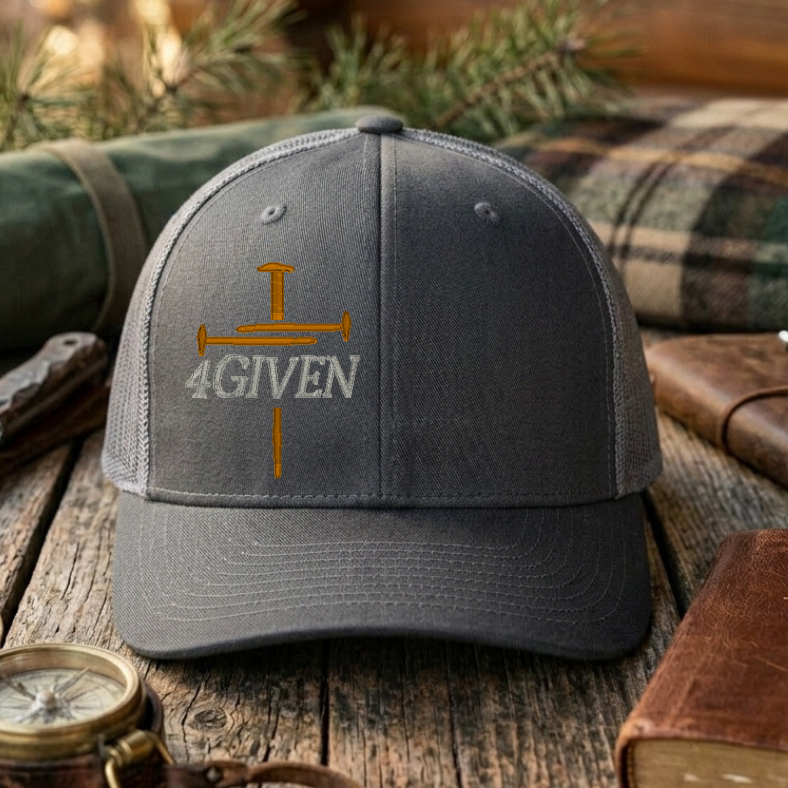 Charcoal & Grey cap with embroidered cross & '4GIVEN' text on a wooden surface with outdoor items.