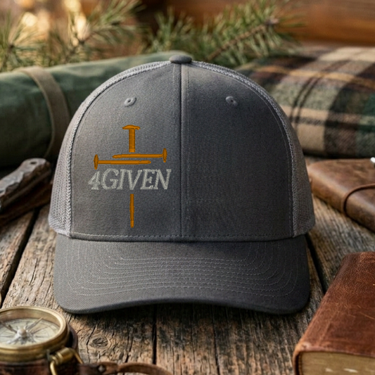 Charcoal & Grey cap with embroidered cross & '4GIVEN' text on a wooden surface with outdoor items.