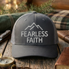 Gray cap with 'Fearless Faith' text on a wooden surface with outdoor items.