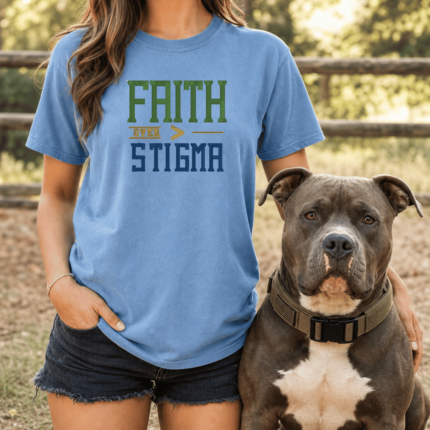 Woman wearing Faith Over Stigma tee in Blue Jean sitting on couch with grey bully breed dog