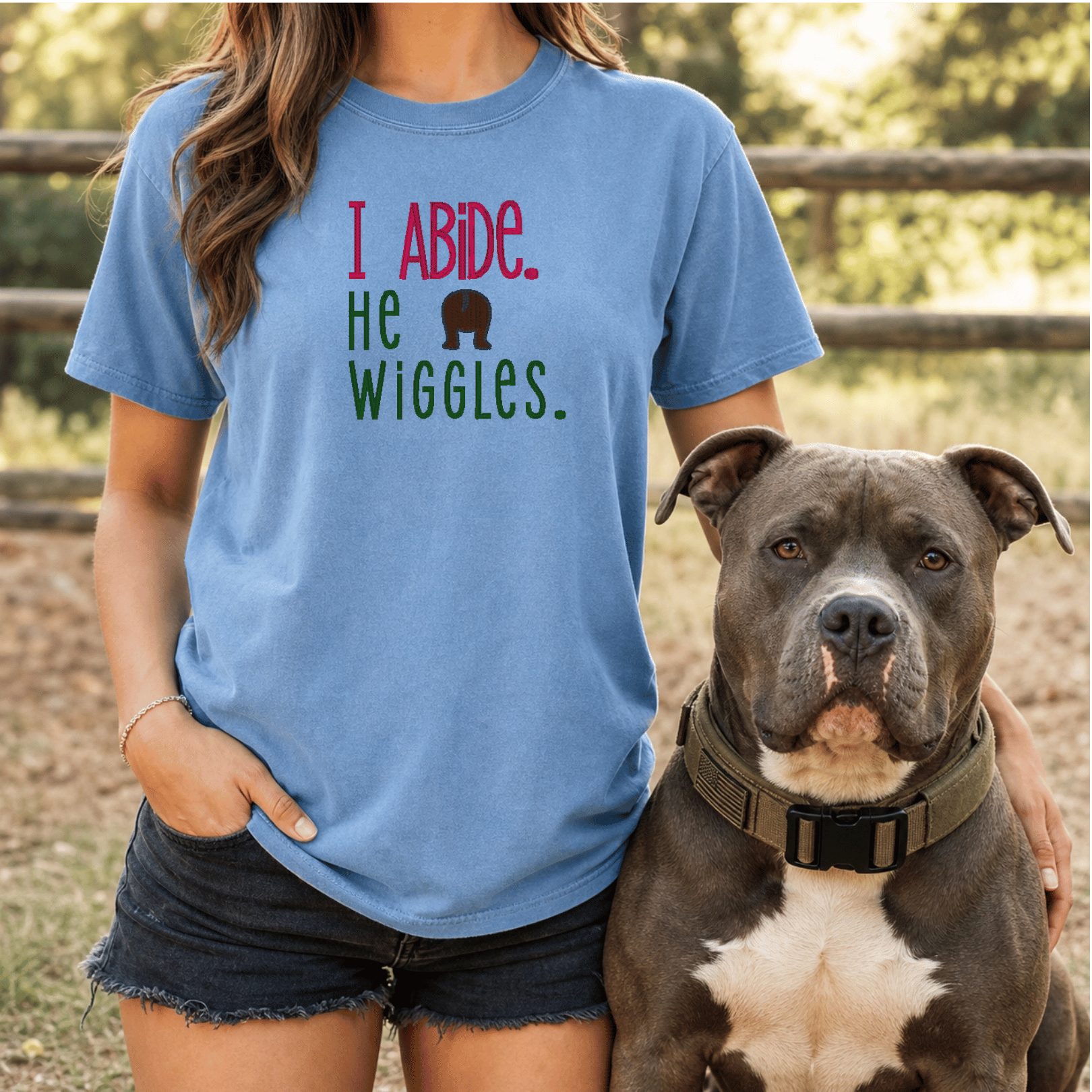 Woman wearing I Abide He Wiggles tee in Blue Jean with bully breed dog