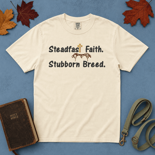 Steadfast Faith Stubborn Breed Comfort Colors Tee in Ivory flatlay with Holy Bible and dog leash