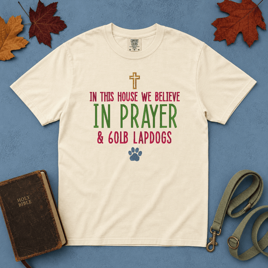 In This House We Believe in Prayer and 60lb Lapdogs Comfort Colors Tee in Ivory flatlay with Holy Bible and dog leash