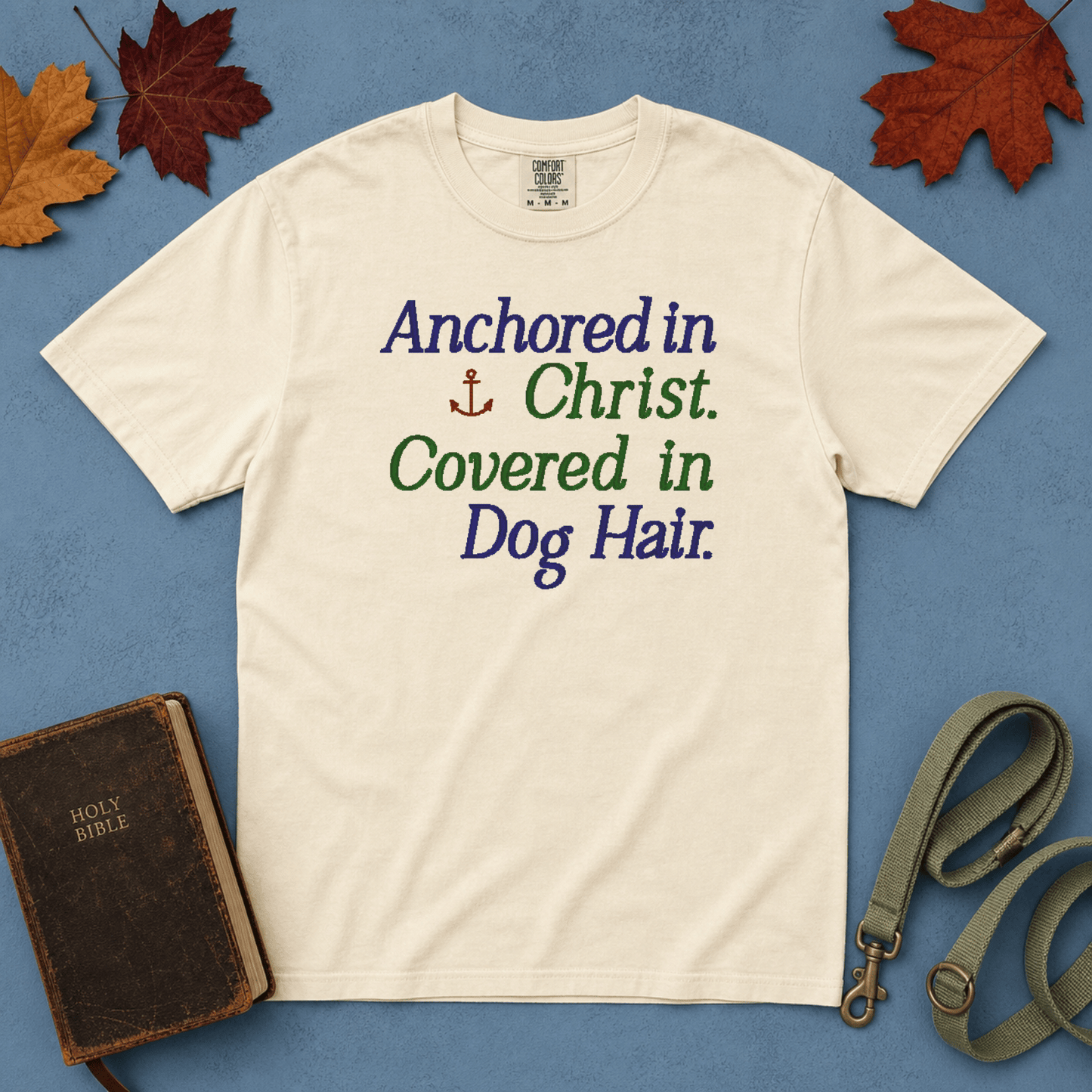 Anchored in Christ Covered in Dog Hair Comfort Colors Tee in Ivory flatlay