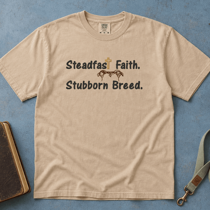 Steadfast Faith Stubborn Breed Comfort Colors Tee in Sandstone flatlay with Holy Bible and dog leash