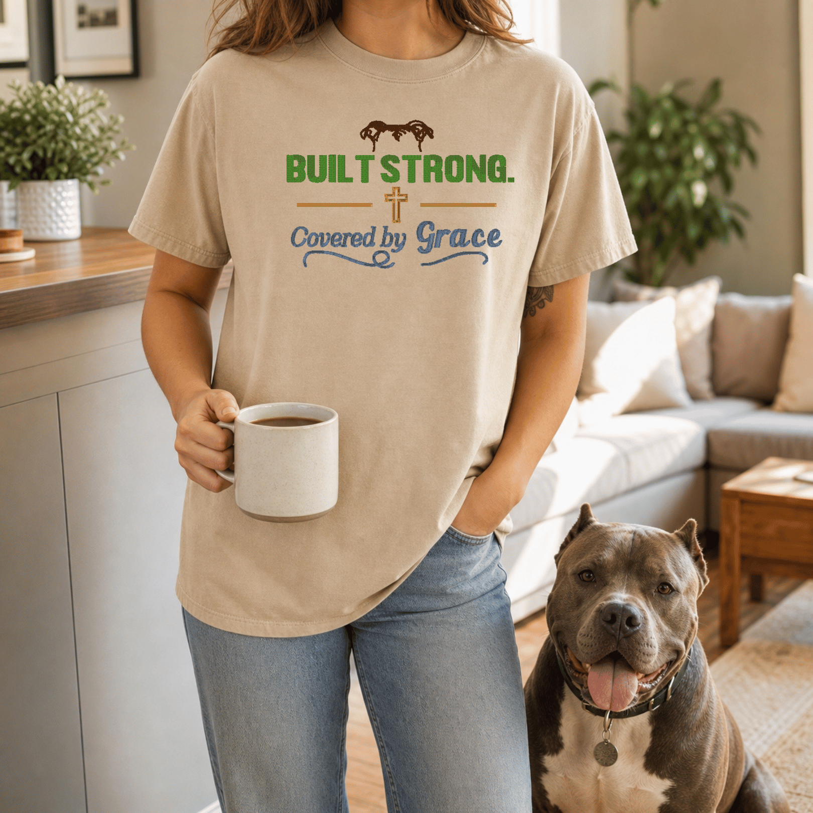 Woman wearing Built Strong Covered by Grace tee in Sandstone standing with bully breed dog outdoors