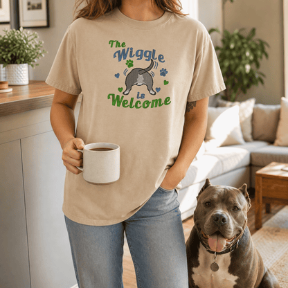 Sandstone 'The Wiggle is Welcome' Comfort Colors tee flatlay with fall leaves, Holy Bible, and olive dog leash