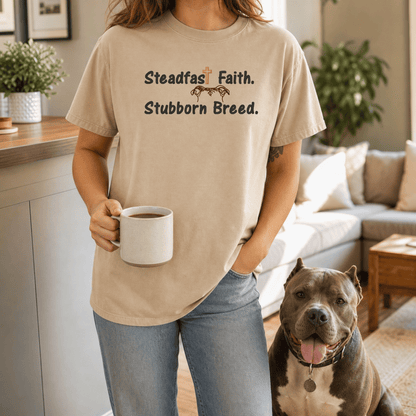 Woman wearing Steadfast Faith Stubborn Breed tee in Sandstone holding coffee with bully breed dog