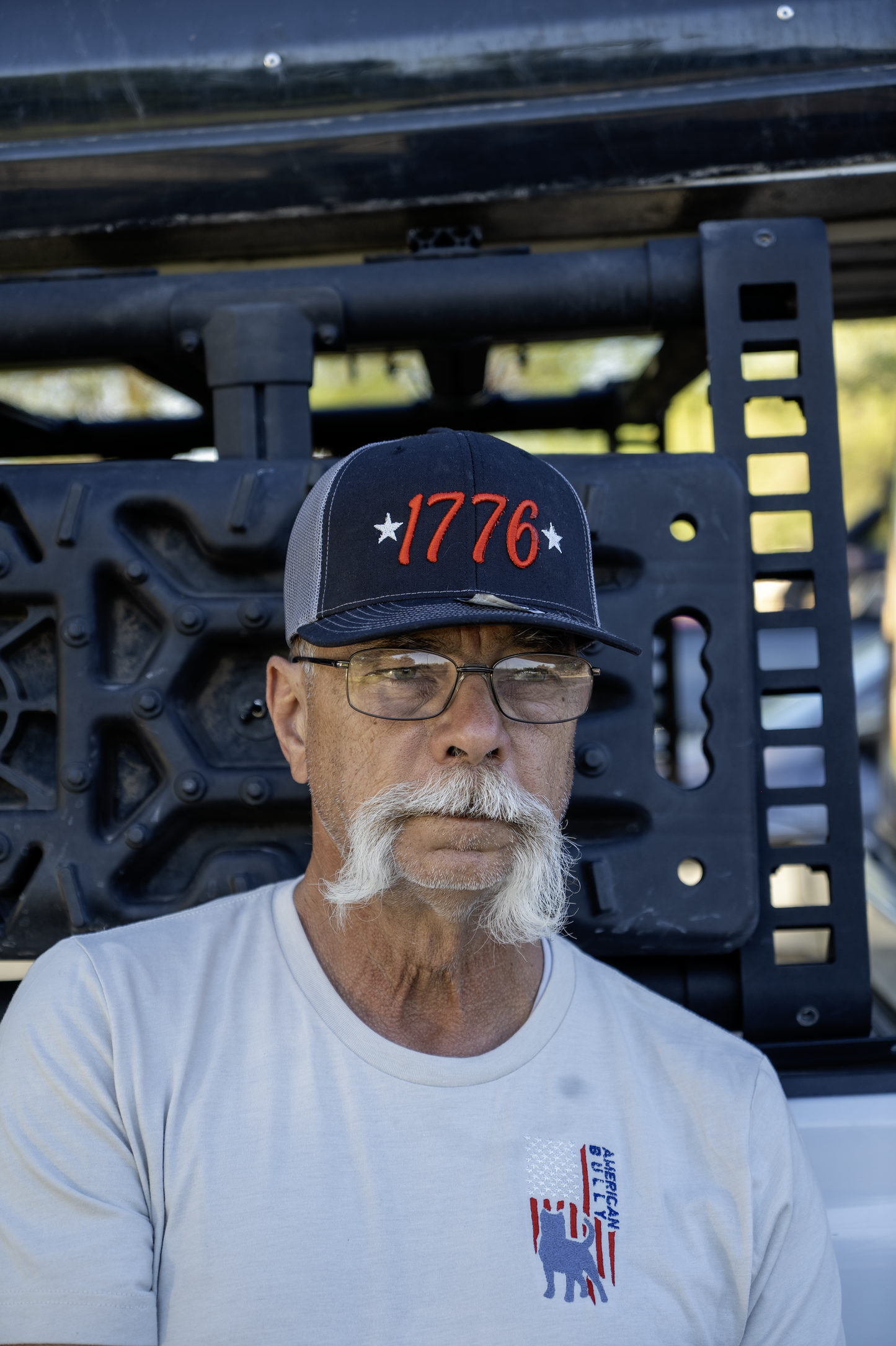 Lifestyle image of a man wearing American Bully Flag embroidered tee in Ivory and Richardson 112 1776 Puff embroidery hat – Abiding Paws
